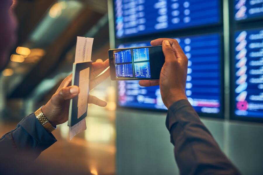 Viajante a tirar fotografia à informação do seu voo