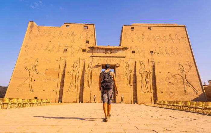 Um jovem turista a entrar no Templo de Edfu, na cidade de Edfu, no Egito