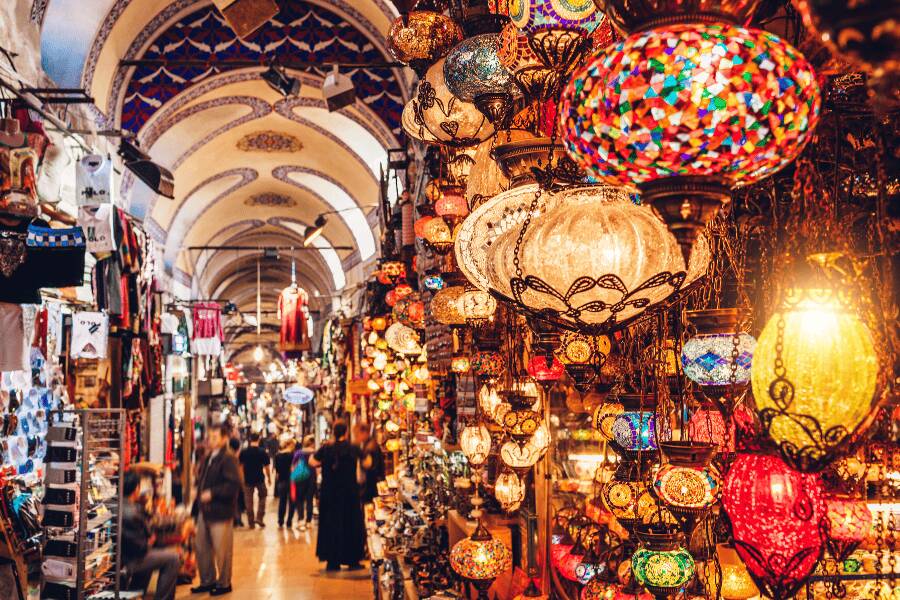 Interior do Grande Bazar de Istambul repleto de lâmpadas artesanais e especiarias tradicionais.