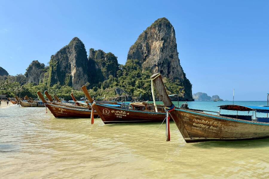 Barcos de cauda longa estacionados na areia em Railay Beach, Krabi, Tailândia