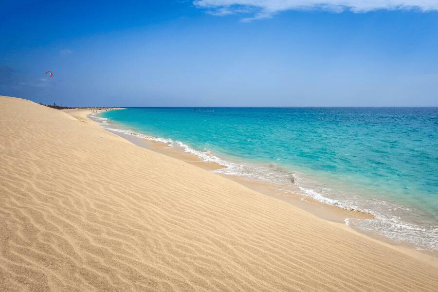 Dunas de areia clara e mar turquesa na Praia de Chaves, Boavista.