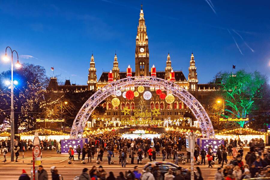 Mercado de inverno e iluminação festiva em frente à Câmara Municipal de Viena.