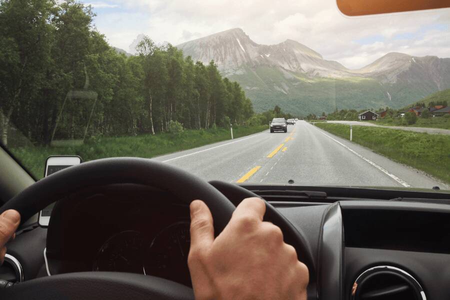 Pessoa a conduzir um carro de aluguer numa autoestrada nos Estados Unidos.